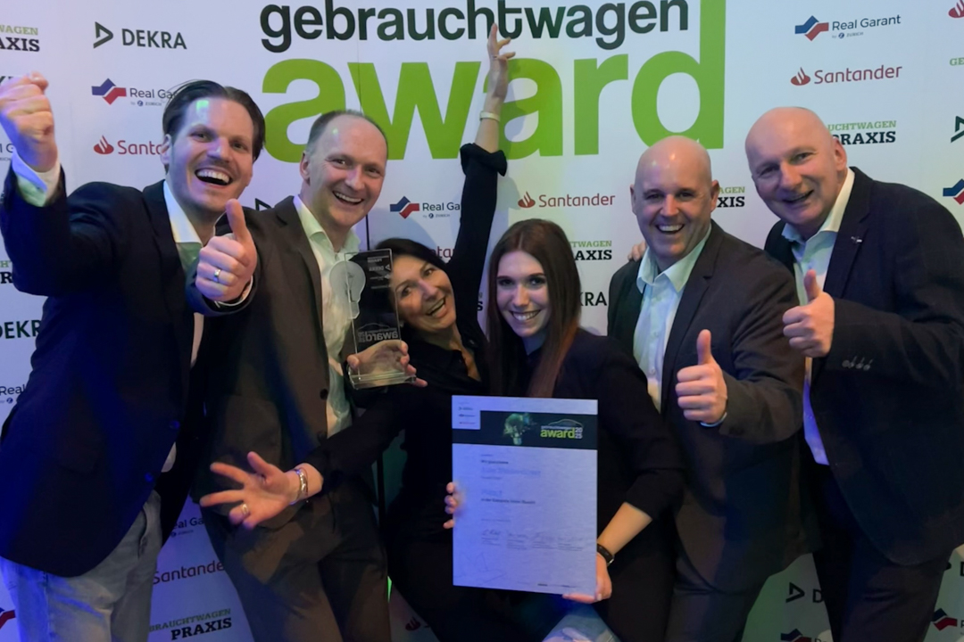 Zu sehen sind Mitarbeiter des Autohauses, die die Gebrauchtwagen Award Auszeichnung hochhalten.