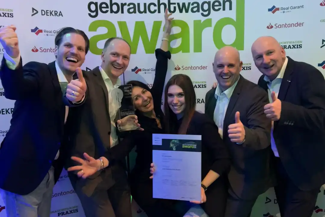 Zu sehen sind Mitarbeiter des Autohauses, die die Gebrauchtwagen Award Auszeichnung hochhalten.