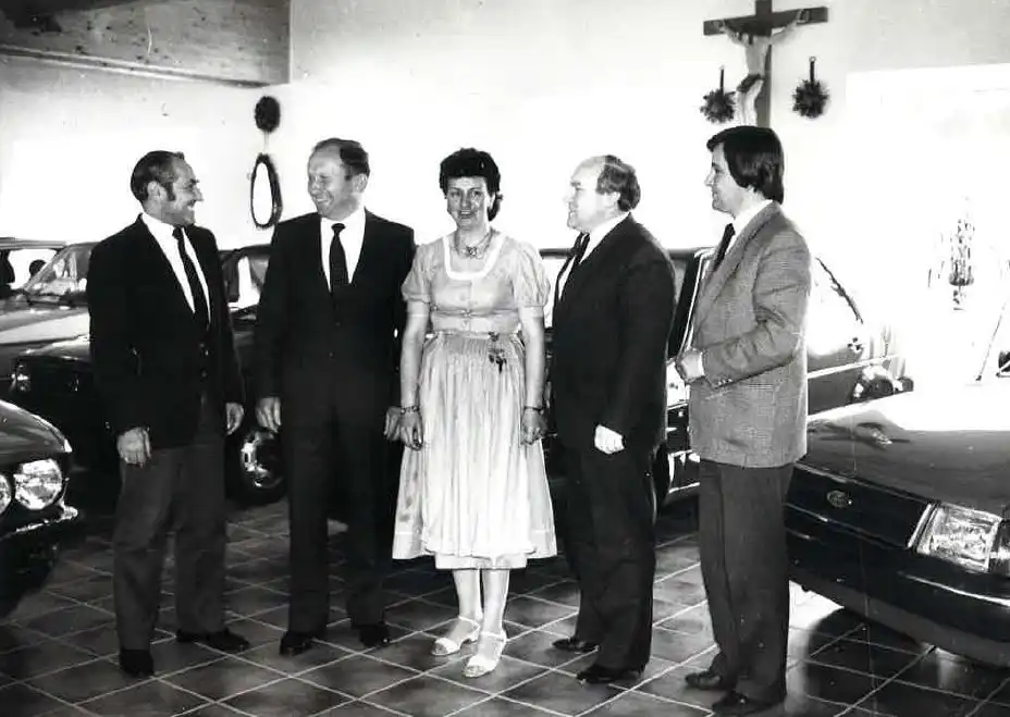 zu sehen ist ein schwarz-weißes Foto von Personen im Autohaus 